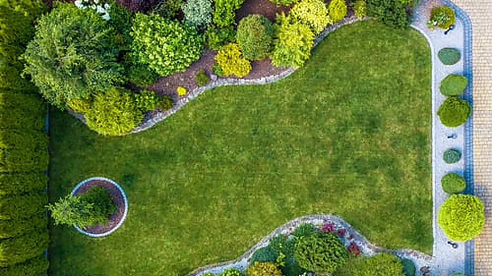 Designed landscape bed and manicured lawn viewed from above