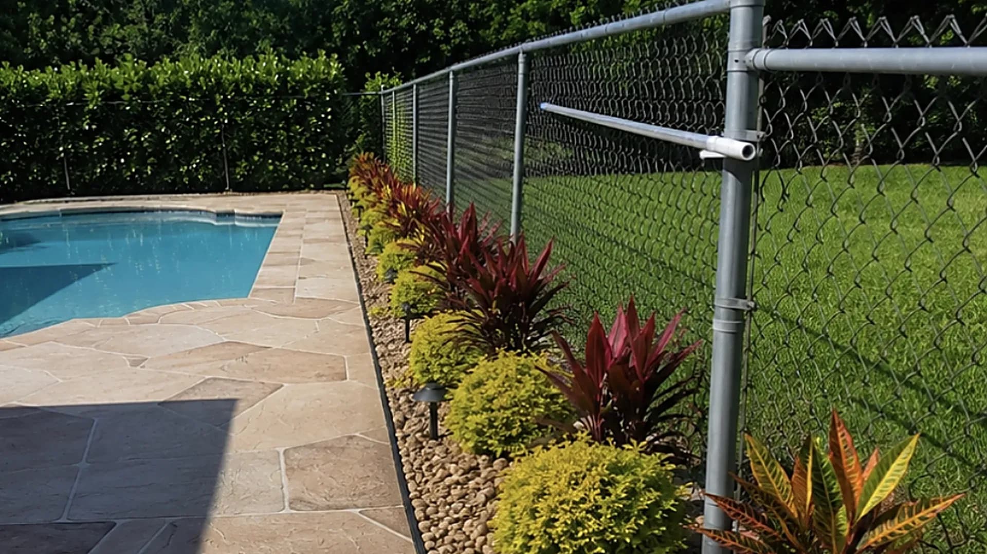 Landscaped pool deck with new fencing and planted beds completed by Fressly Cut Green Lawn Inc in Jupiter, Florida